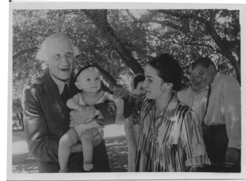 Photograph of Hewlett holding a young child during an international visit
