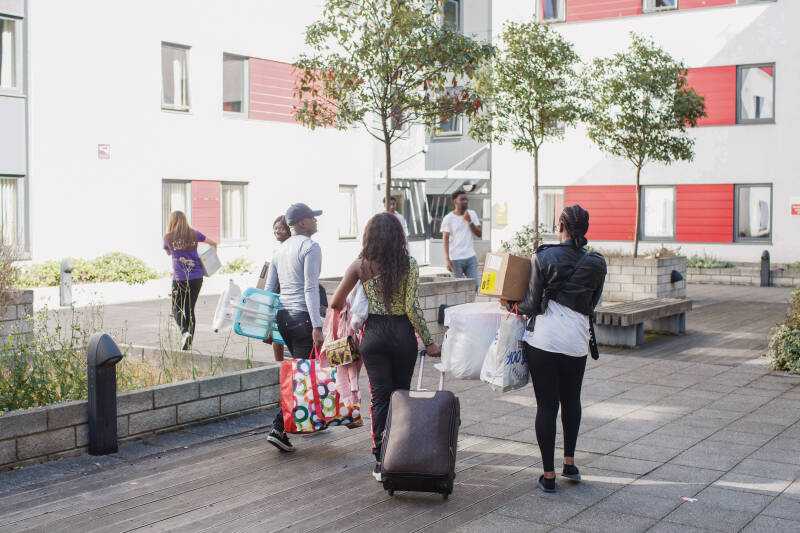 Group of students and family moving items into Pier Quays