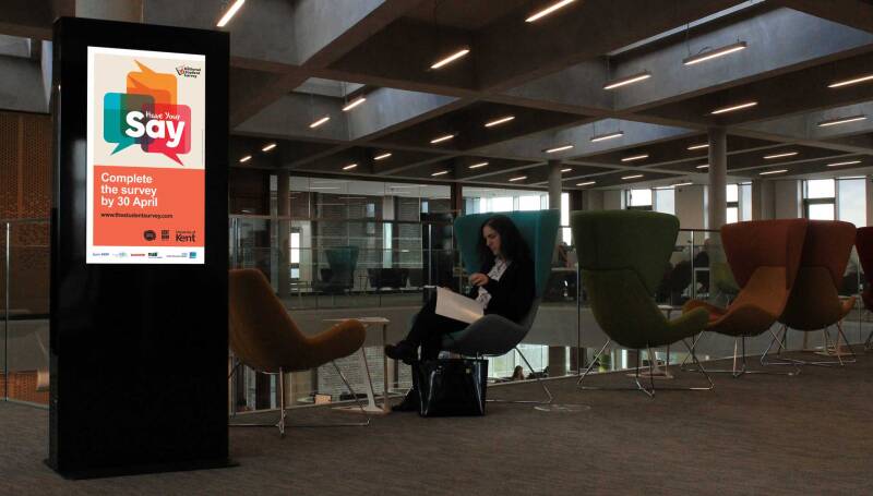 Digital screen showing advert for National Student Survey in study area with comfy seating