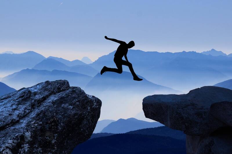 A person jumping between two mountains