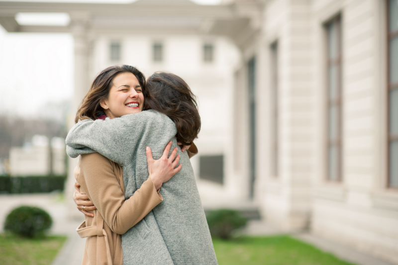 Two women hugging outside