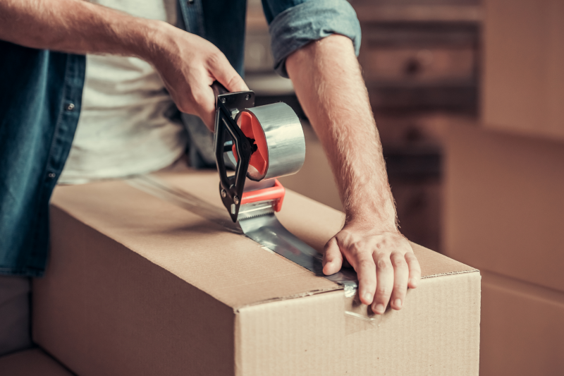 Man sealing a packing box