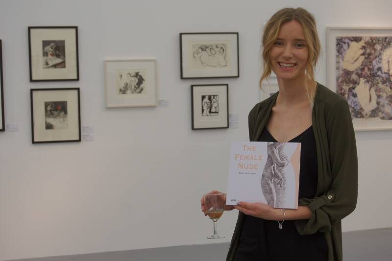 Student proudly holding the exhibition guidebook