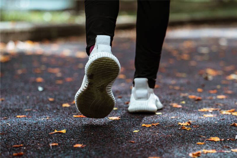 Close-up photo of feet while walking on an outdoor path in Autumn