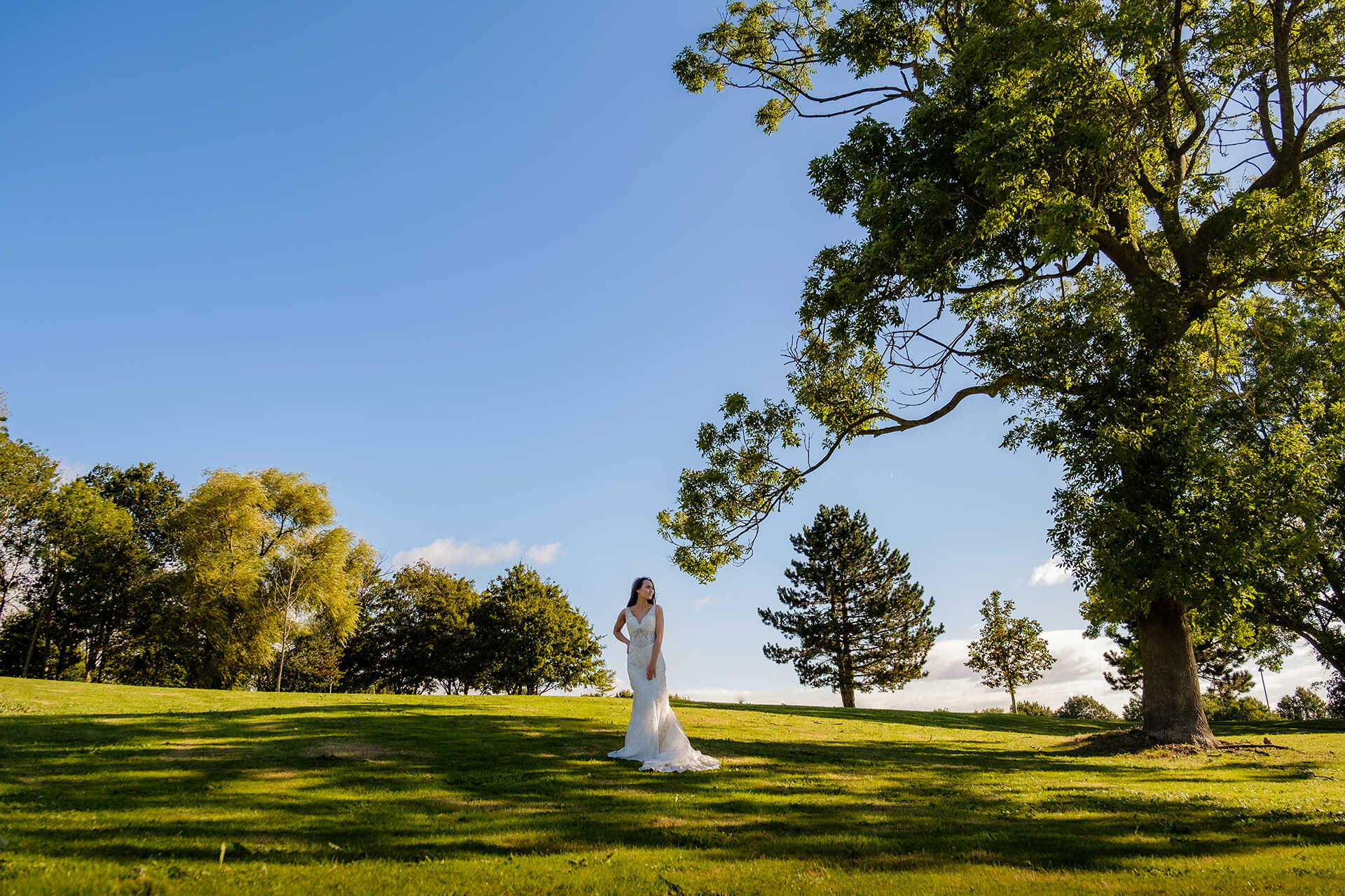 Bride in wedding dress on the Canterbury campus surrounded by trees