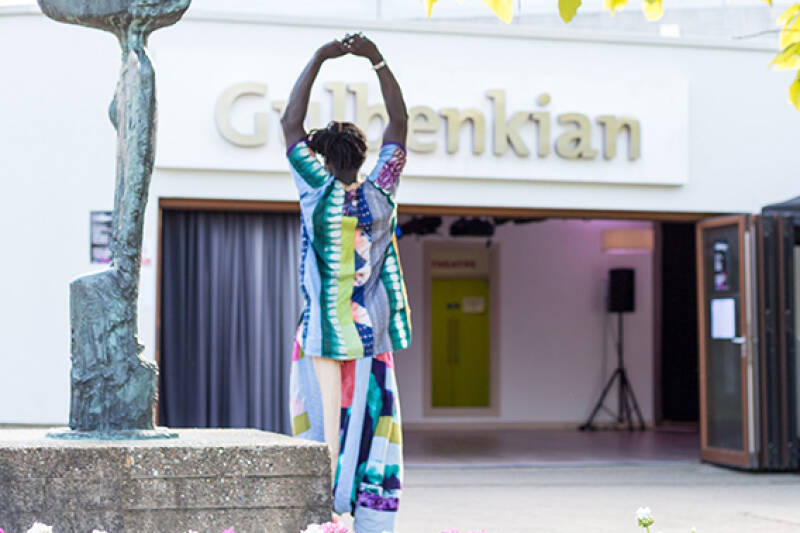 A woman stands beside the statue outside Gulbenkian