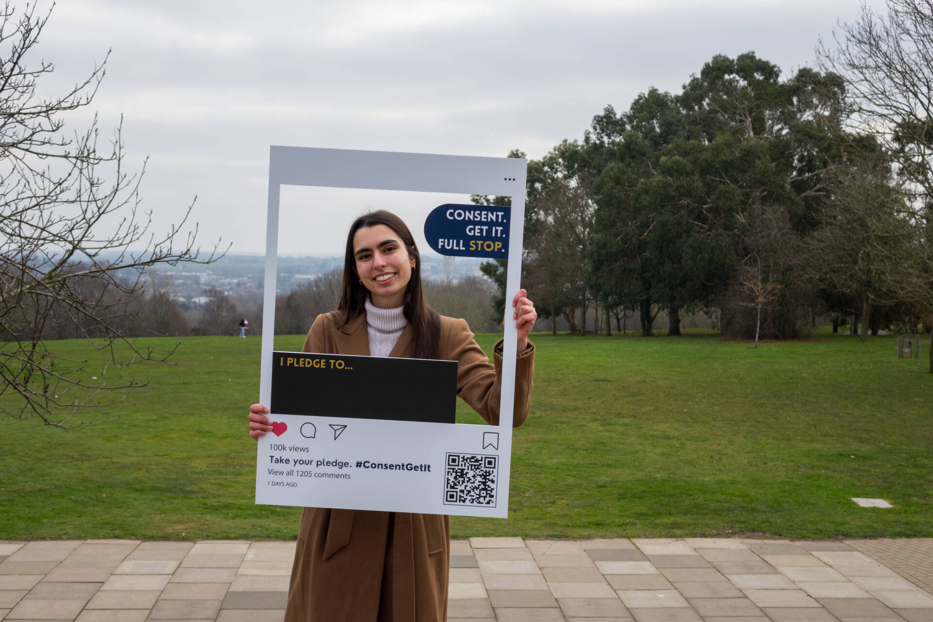 Student Filipa holding a photo frame that says Consent. Get It. Full stop.