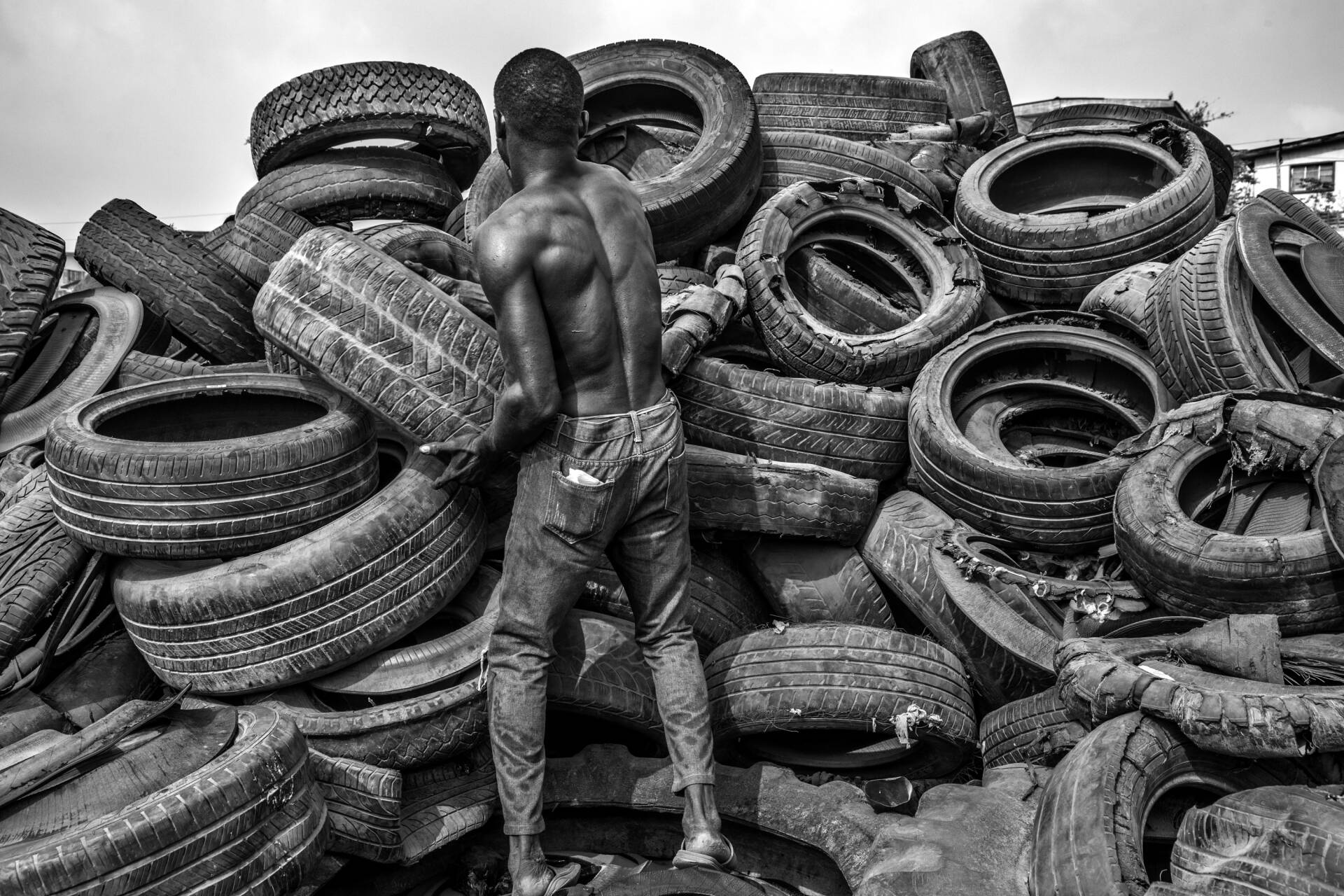 A man is pictured stacking a tyre onto a pile of used tyres