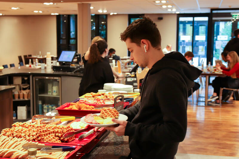 Male student choosing breakfast items in Dolche Vita