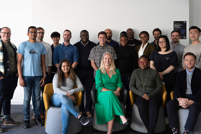 Image of MBA students and staff, smiling into the camera