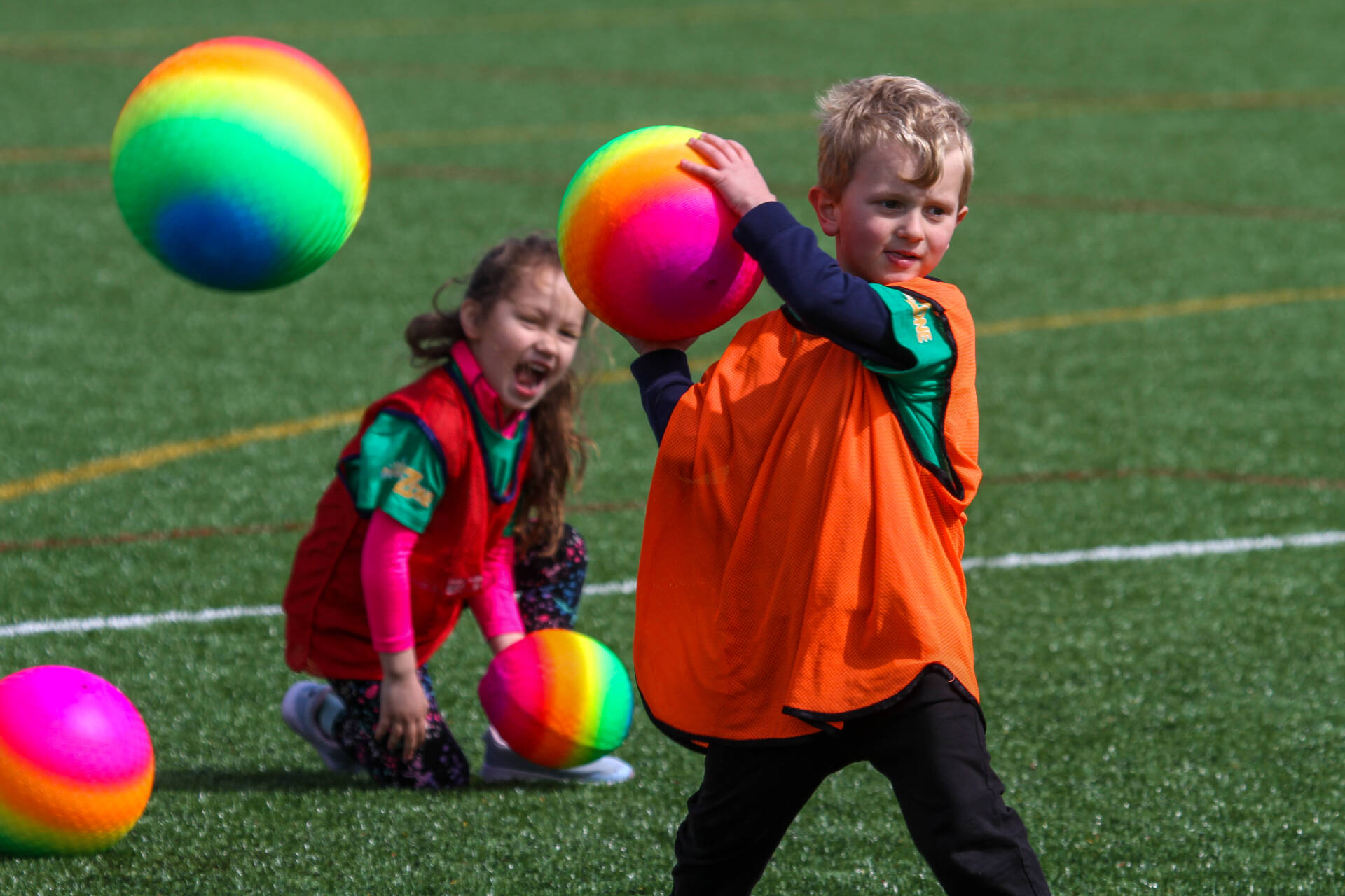 Child about to throw a multi-colour ball during a game of dodgeball