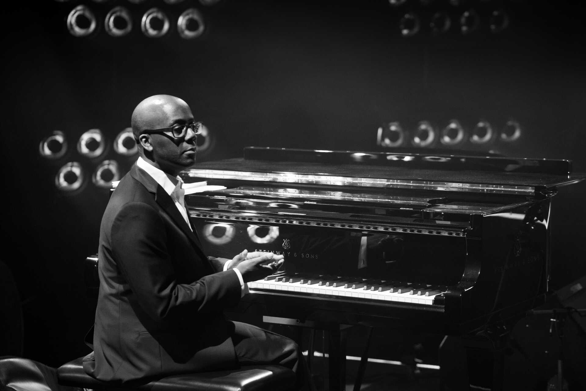 Male pianist sitting at a grand piano, looking to the right