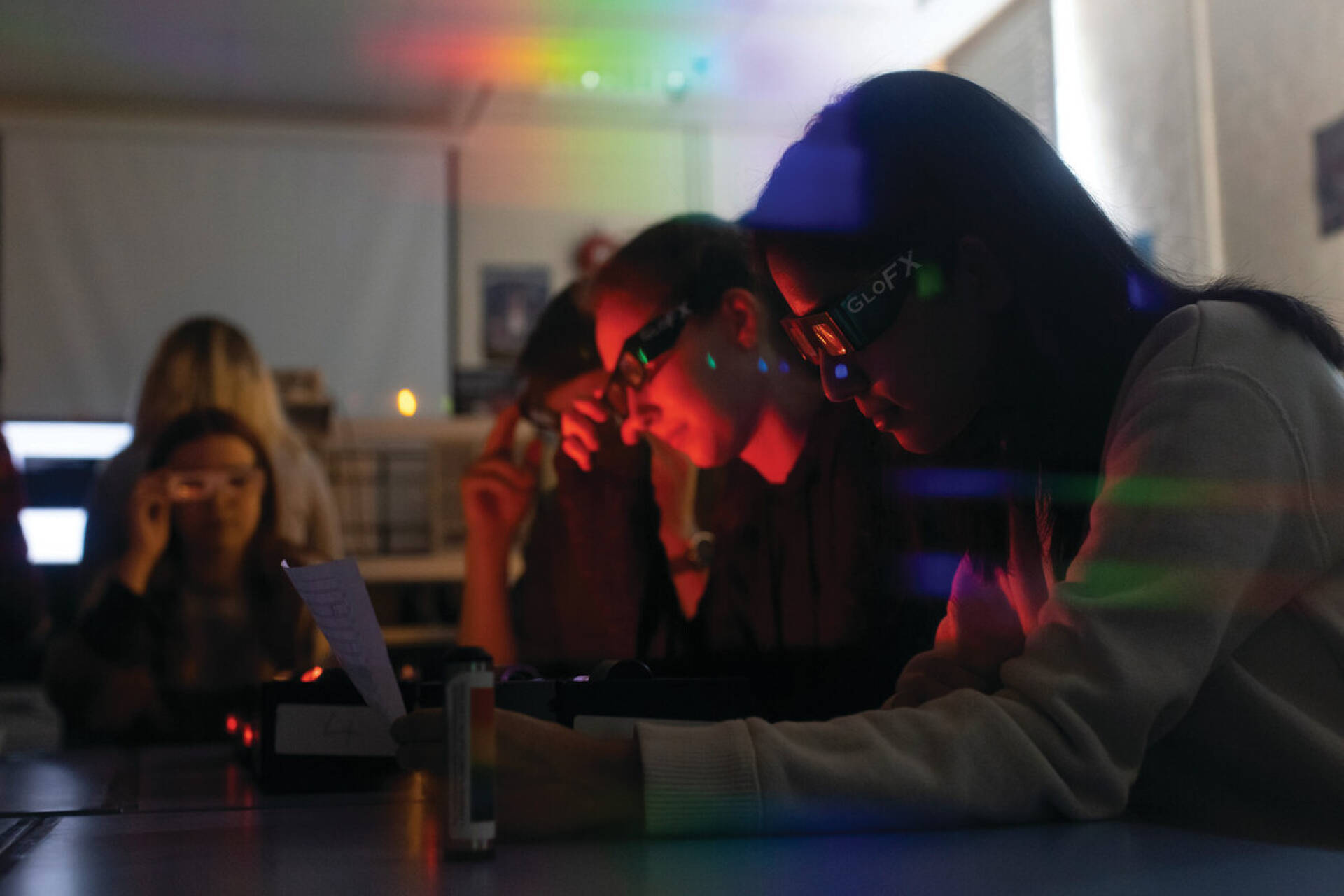 Students studying light wearing 3D glasses.