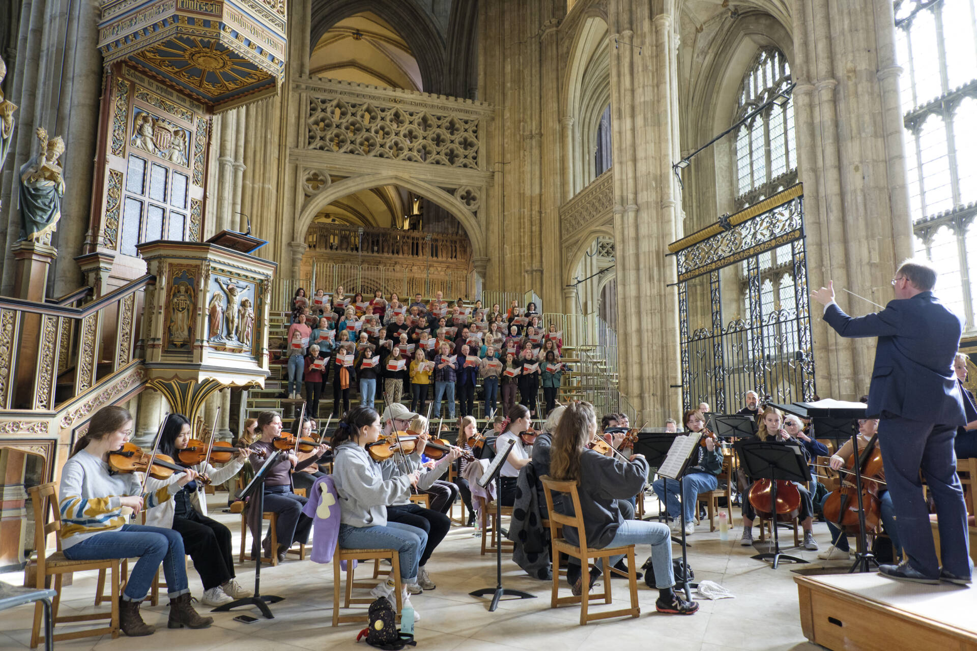 Group of orchestral players and choir rehearsing in the Nave of Canterbury Cathedral
