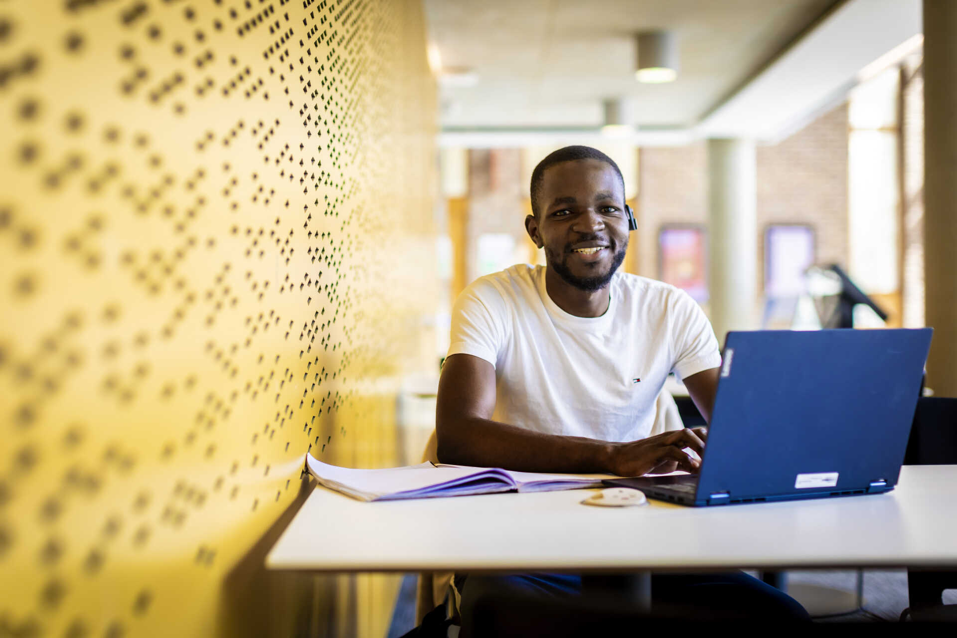 Student on laptop looking to camera