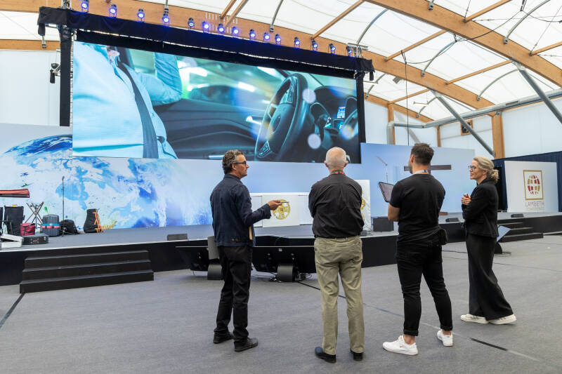 A large room with rows of chairs and a big screen set up