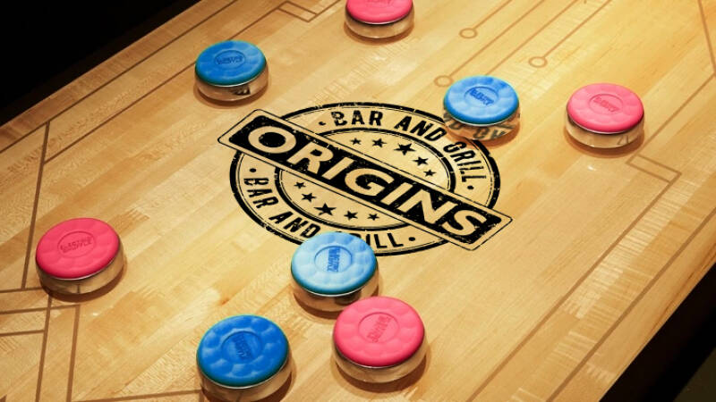Shuffleboard table with Origins logo