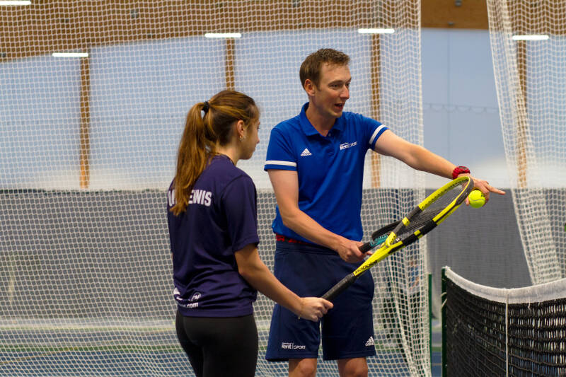 LTA Level 5 coach Nick Skelton demonstrating basic tennis skills with student tennis player.