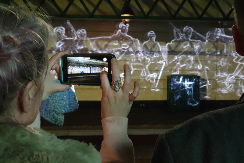 A digital projection being photographed by a mobile phone