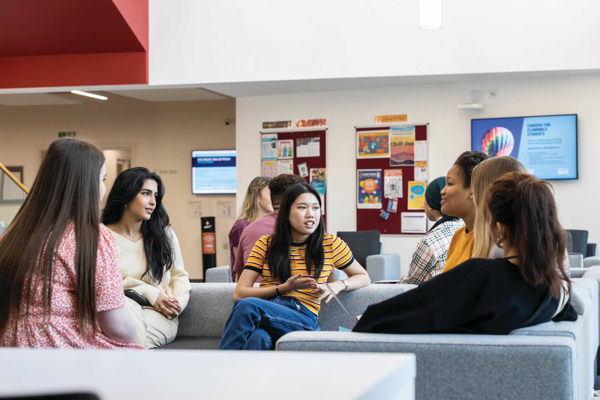 A group of students sitting inside the Kennedy building.