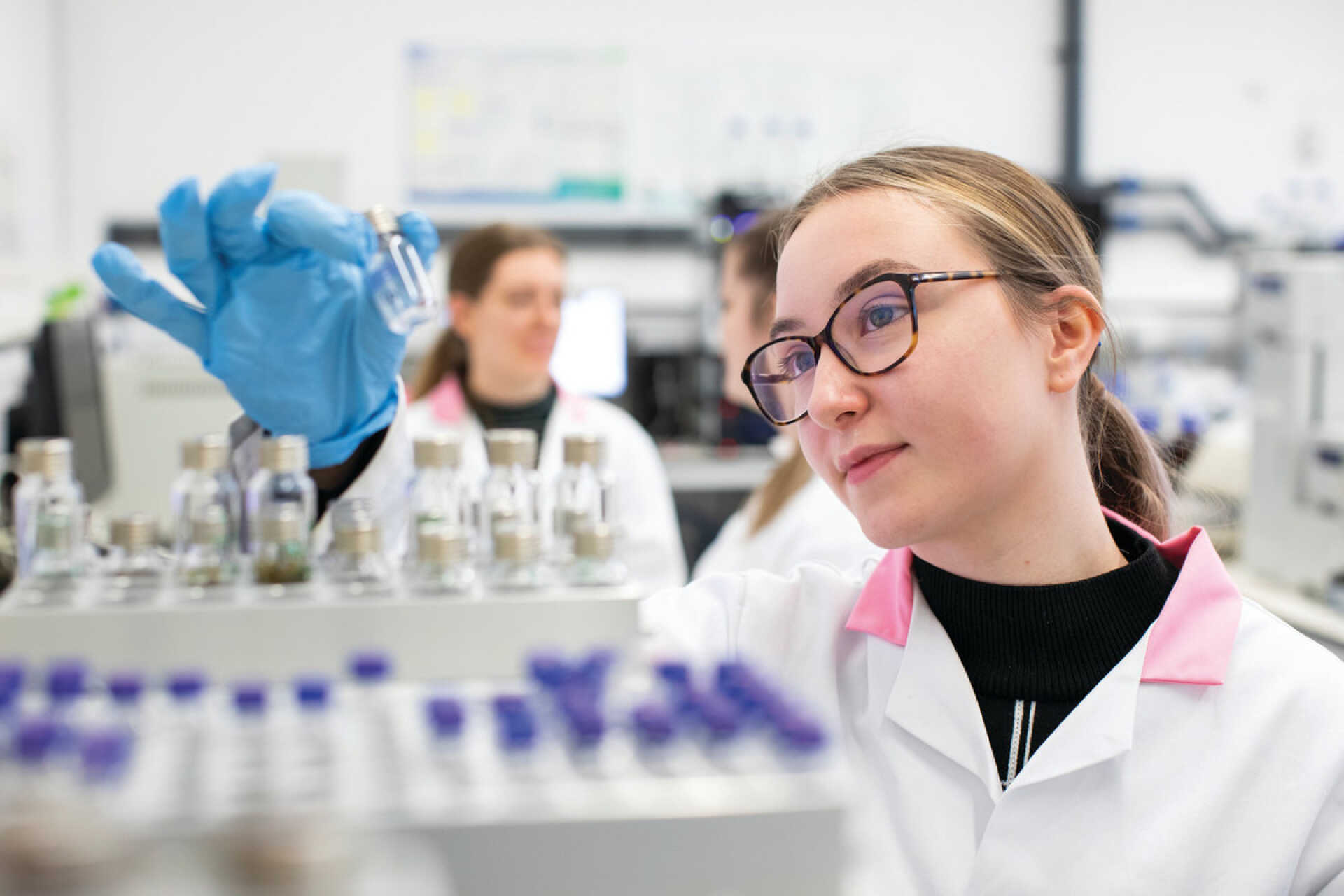Beth in the Chemistry lab looking at vials of powder