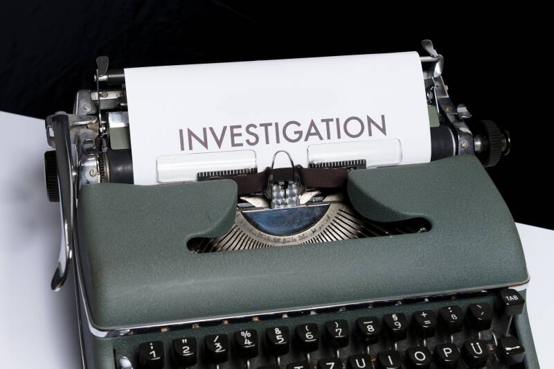 A typewriter with paper visible over the roller. It has the word investigation typed on it.