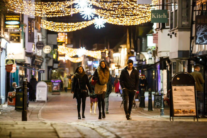 people walking down Canterbury highstreet with Christmas lights