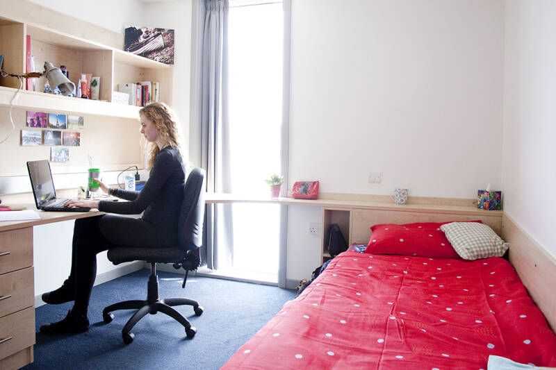Female student working at a laptop in Keynes