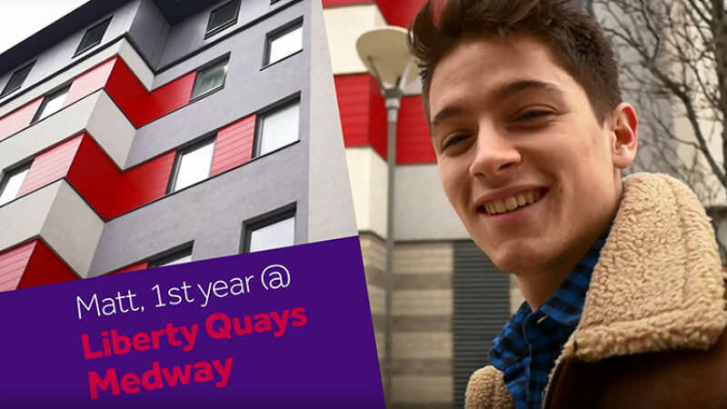 Male student smiling in front of Pier Quays