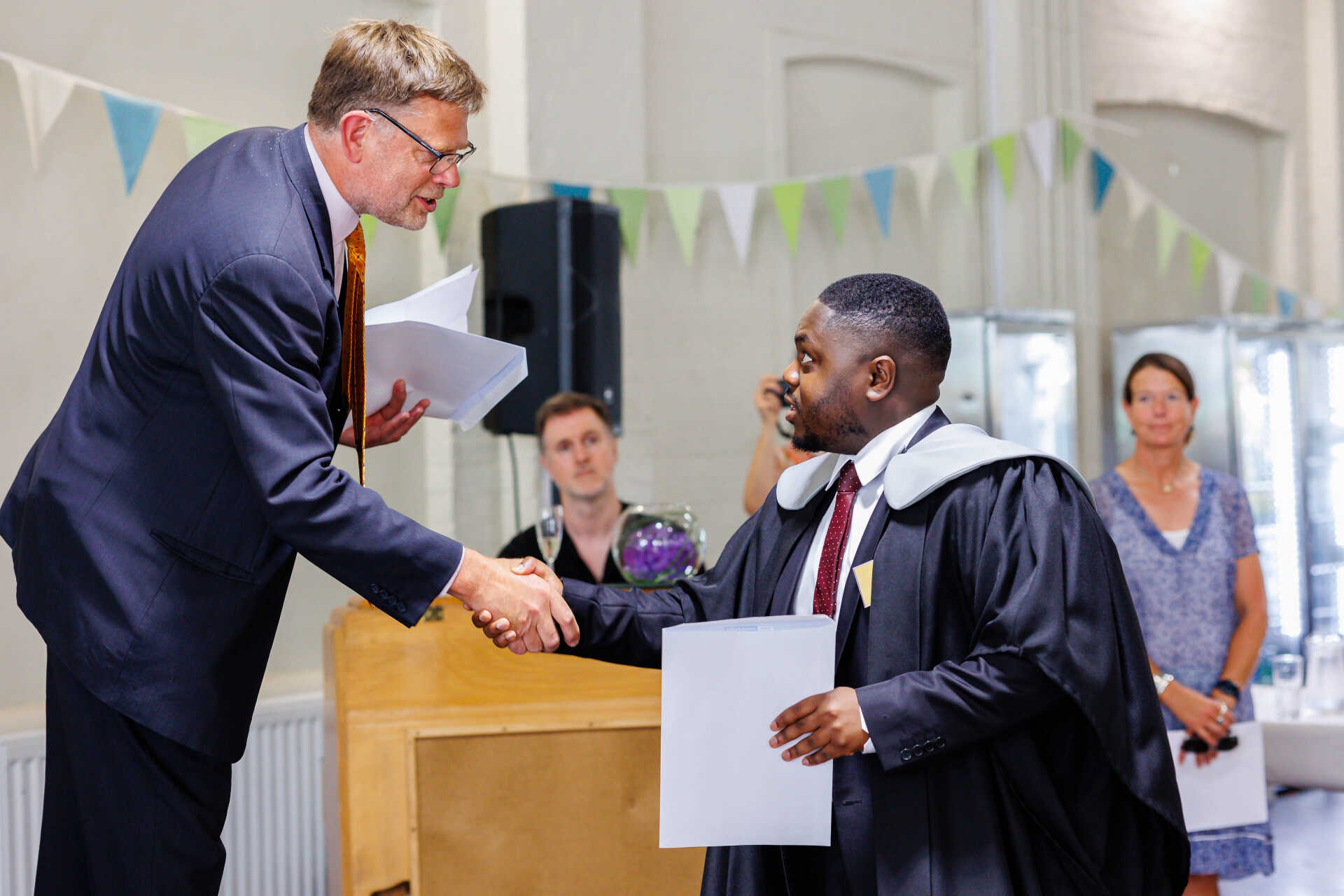 Professor Alastair Bailey congratulates Daniel Tetteh at graduation.