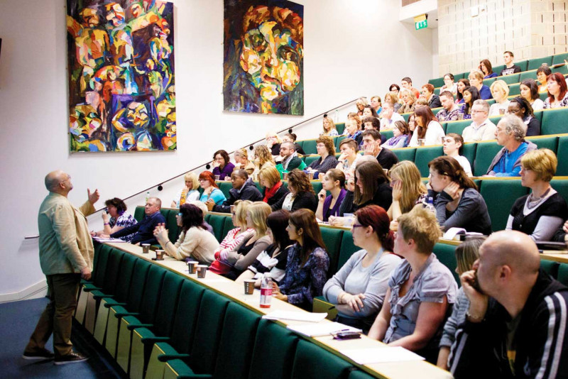 Academic gives a lecture to a hall full of a students