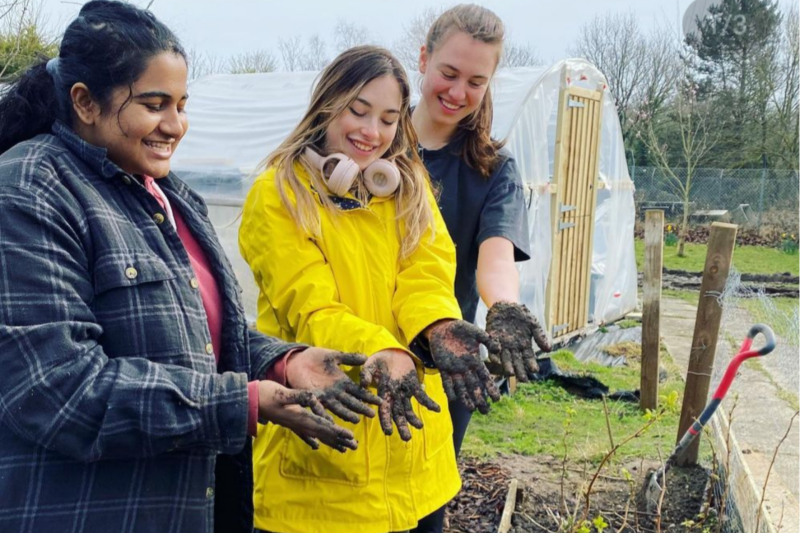 Students showing off their muddy hands in the allotment garden