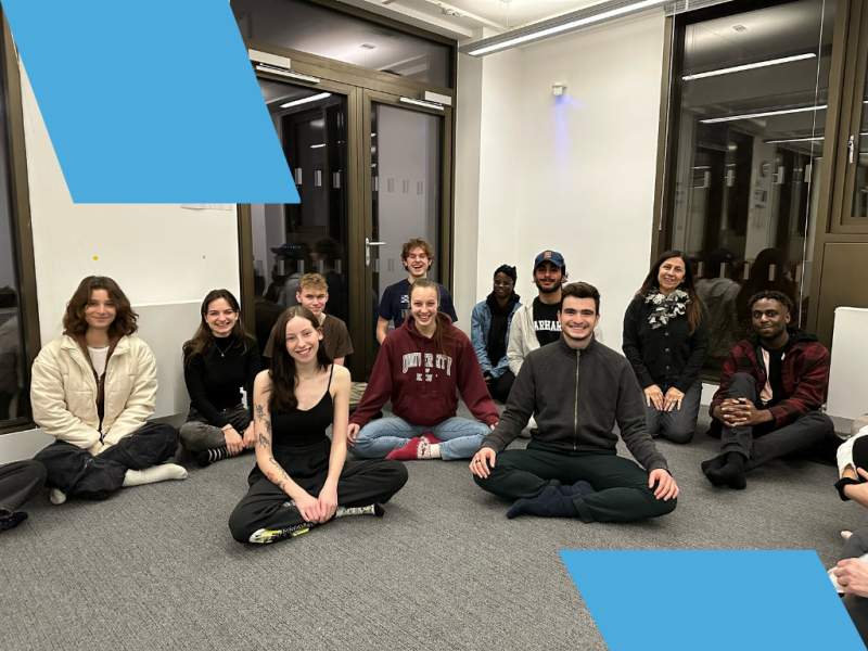 Group of people sat cross-legged on the floor.