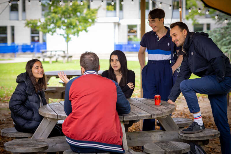 Group of students sat on bench outdoors