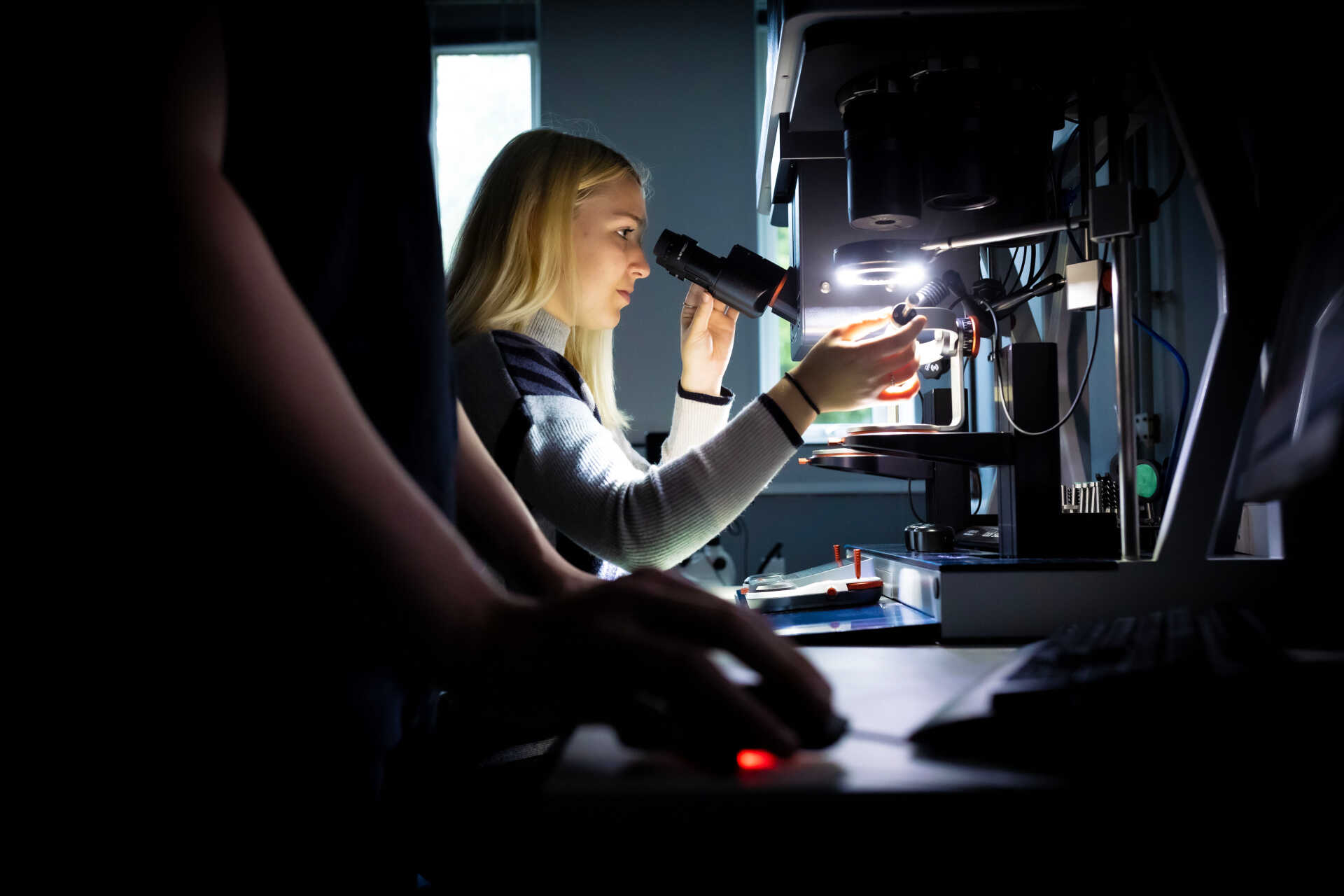 A woman looking into a microscope