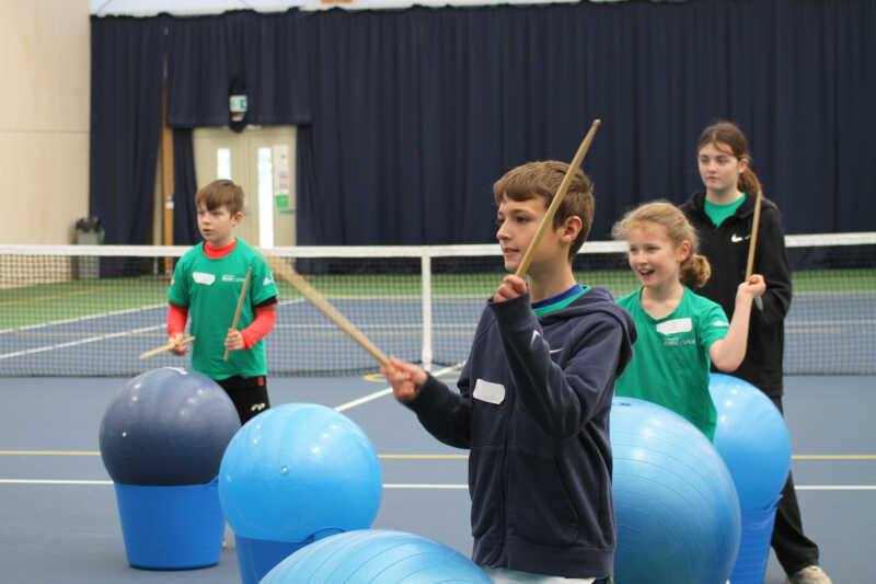 Group of children playing tug of war on an artificial pitch