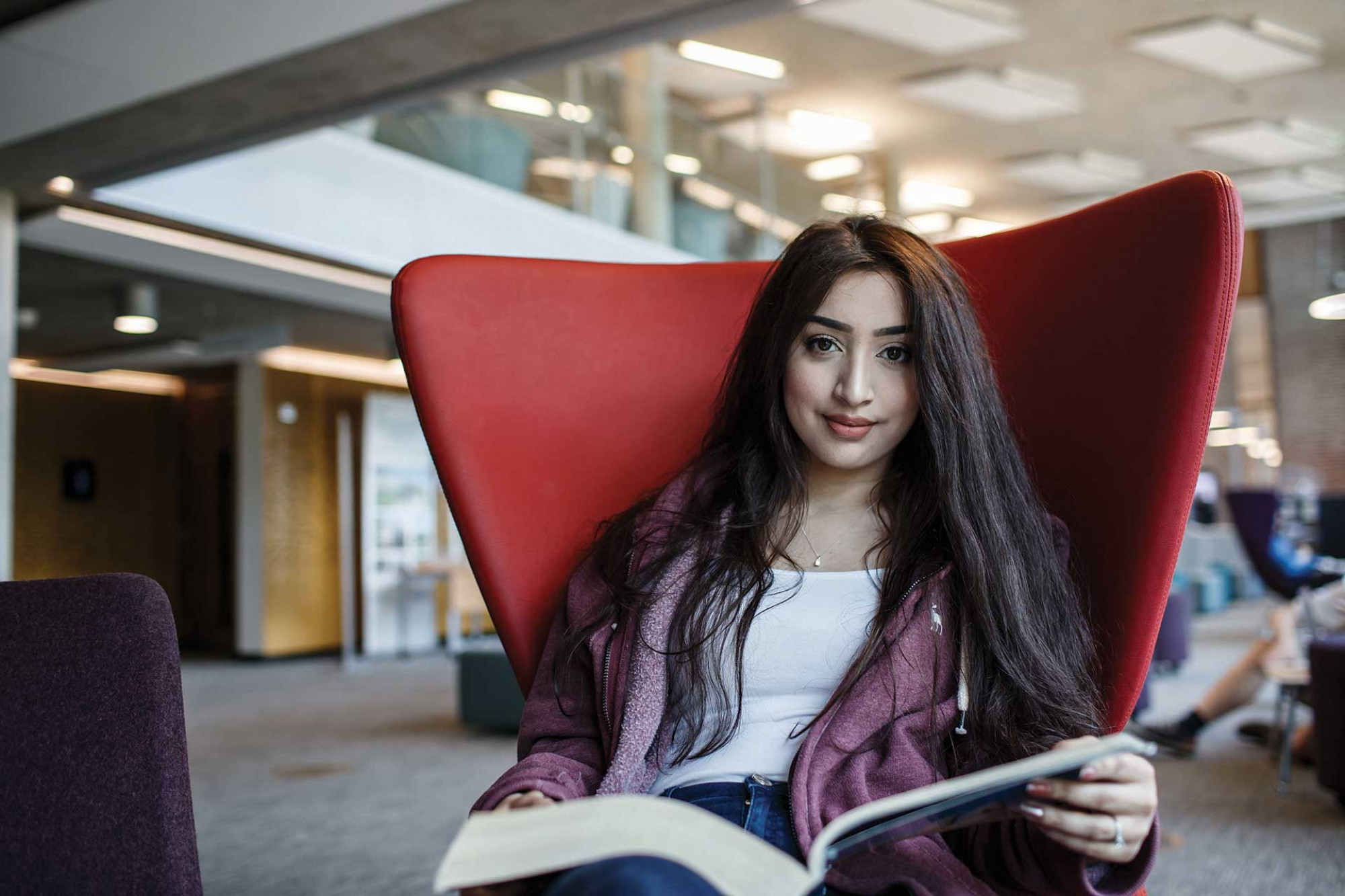 Psychology student Gul sitting on a chair in the Templeman library
