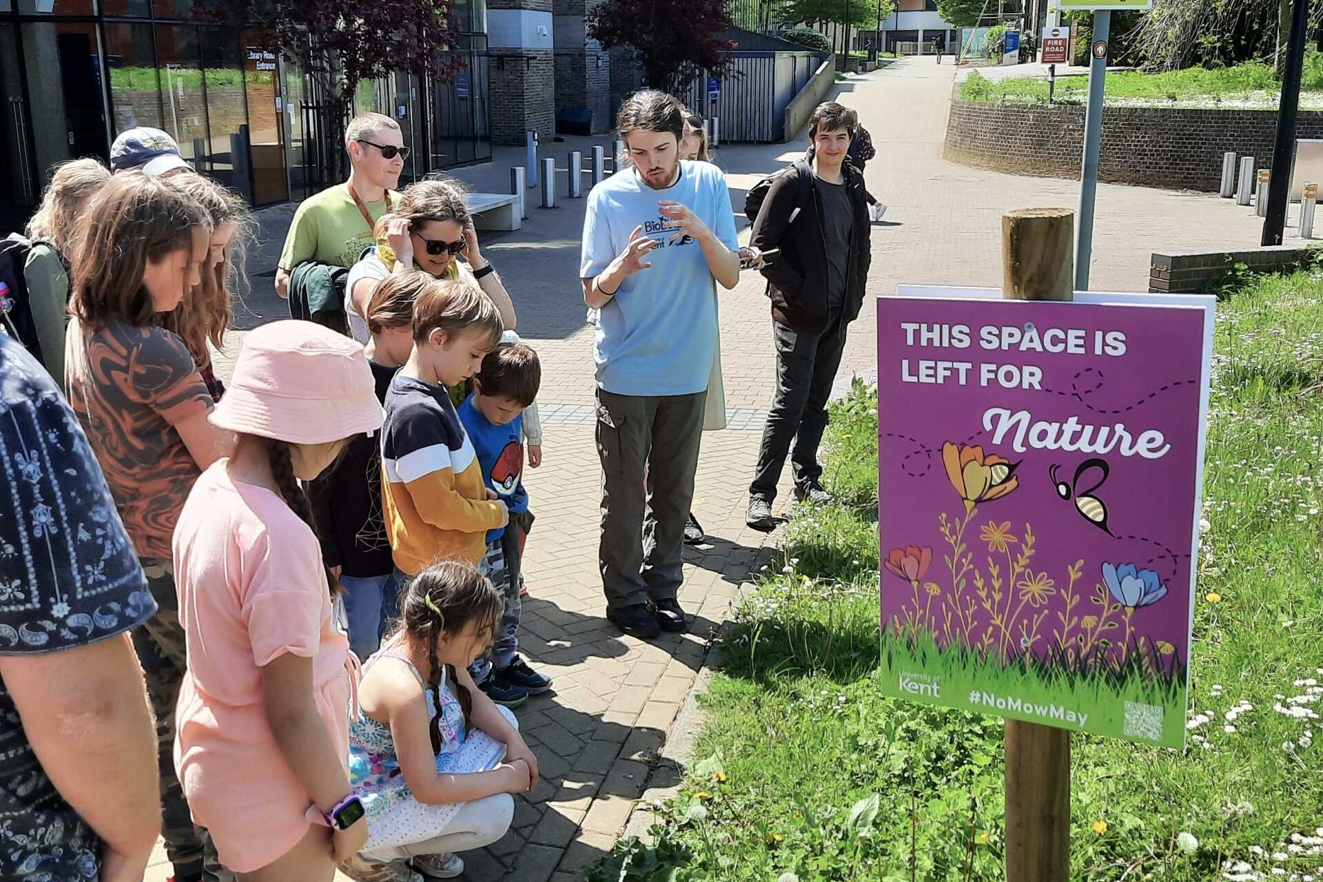Staff, children and students discuss the flowers on campus.