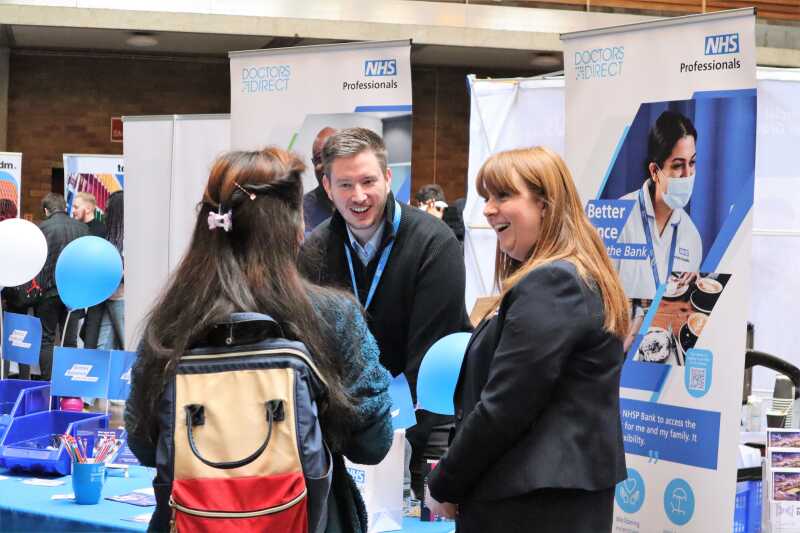 Students and employer chat at a stand.
