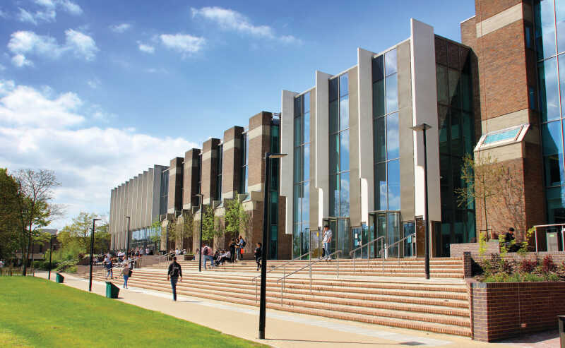 Foyer of Sibson building, students sitting in centre and two staircases