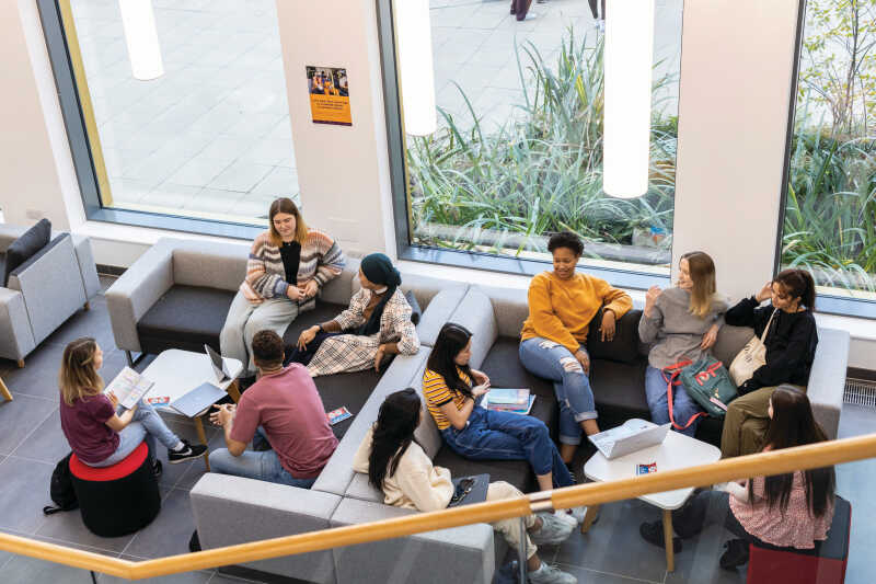 group of students sitting on sofas by window in the Kennedy building