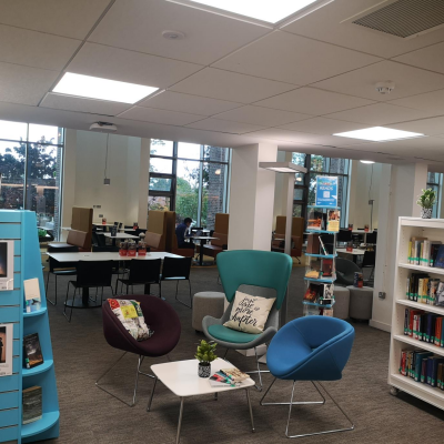 Photo of the Love to Read seating area with comfy chairs and shelves of books