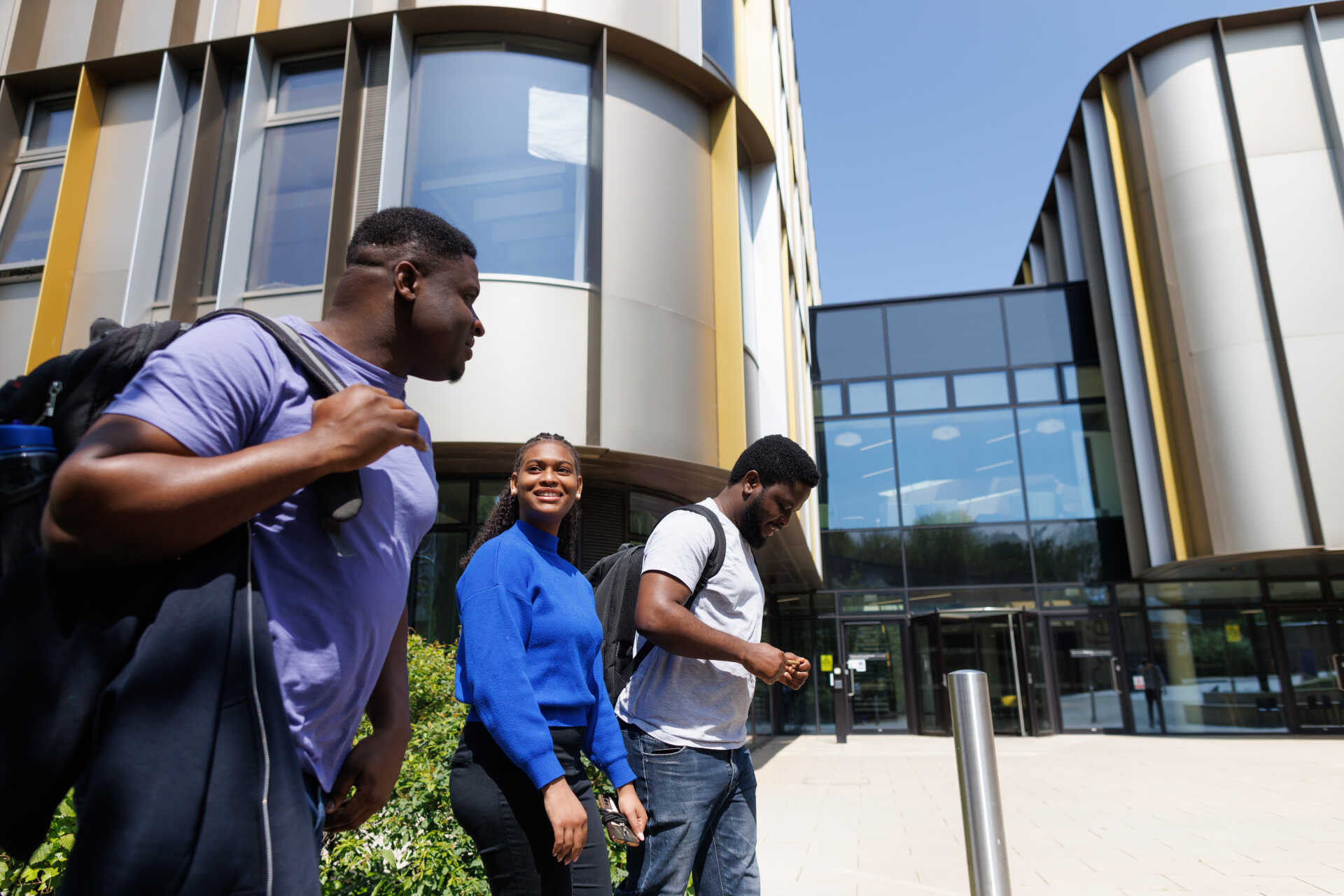 Students walking around the entrance to Sibson, the new business school building