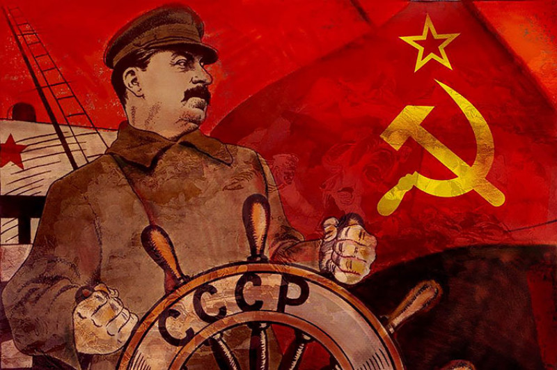 A poster of Stalin at the wheel of a ship, representing the Soviet state. The red flag of Soviet Russia forms the backdrop.