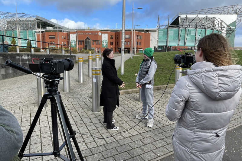 Reporter interviews a football fan outside Celtic Football Club