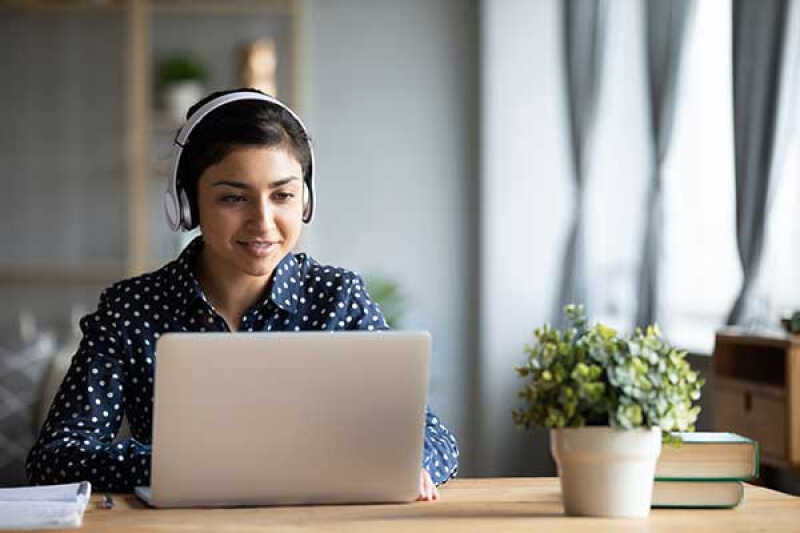 Student wearing headphones and using a laptop
