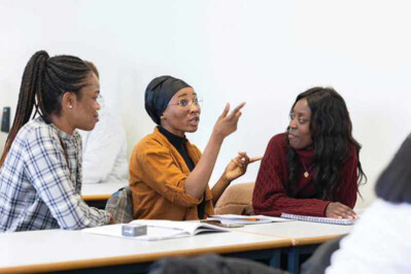 Group of three students in a seminar having a discussion