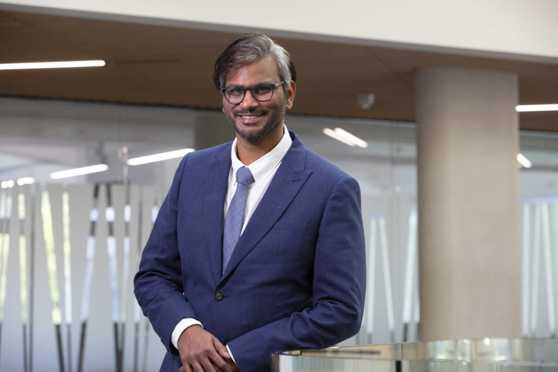 Nikhil Sengupta smiling to the camera in a suit