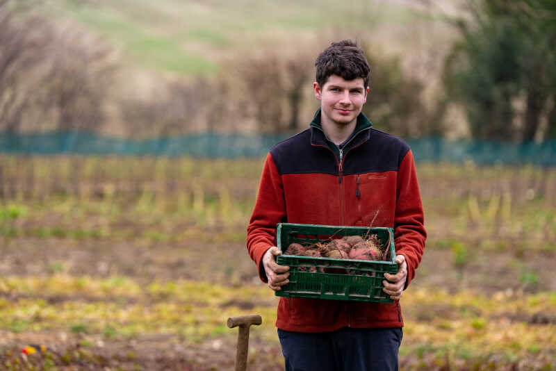 Jack Scott on his farm holding a crate of his beetroot