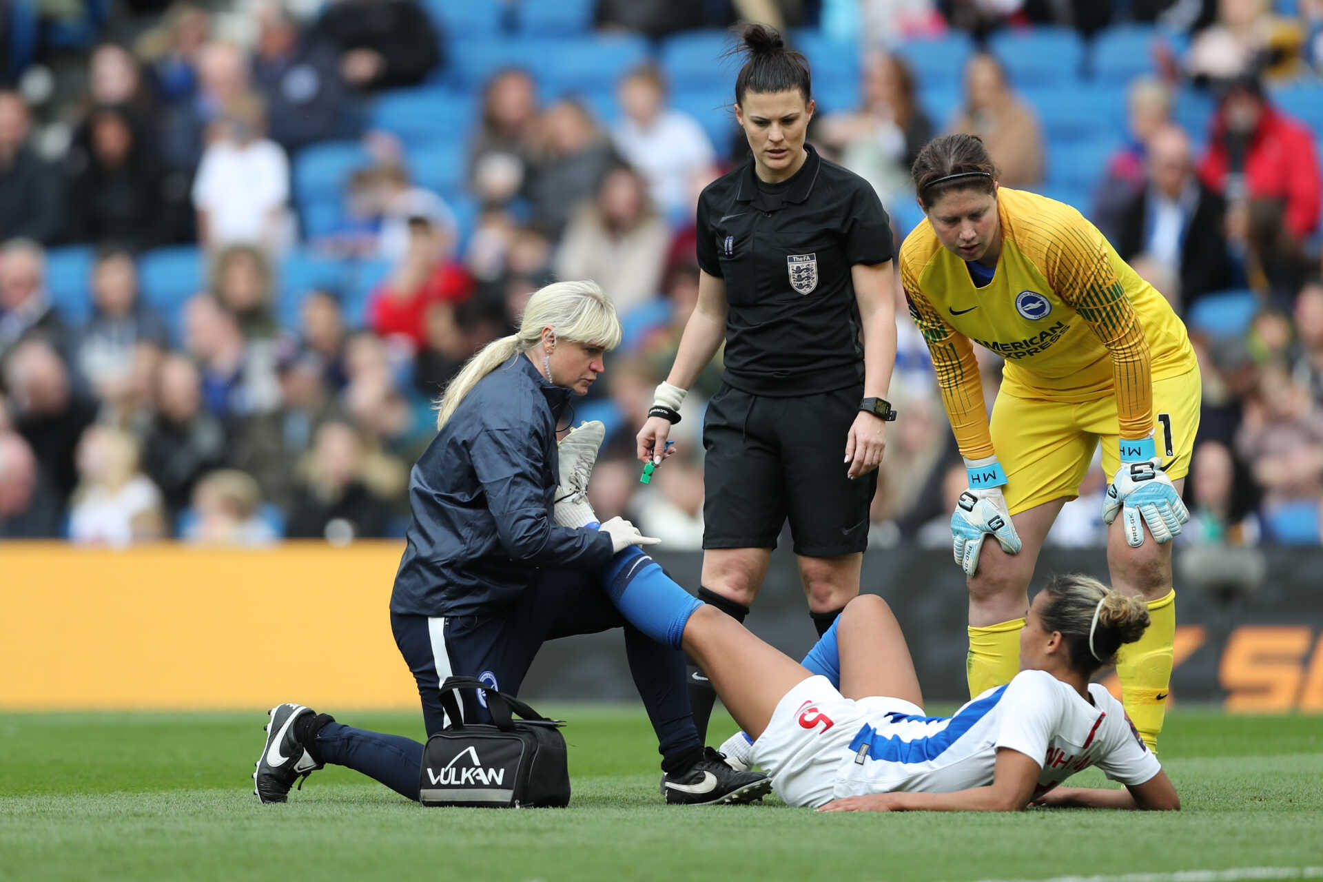 Lisa Walsh tends an injured footballer on the pitch